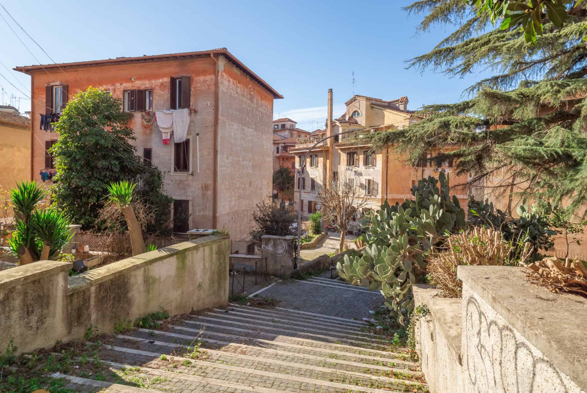 Escalier et maisons basses entourées de verdure dans le quartier de Garbatella