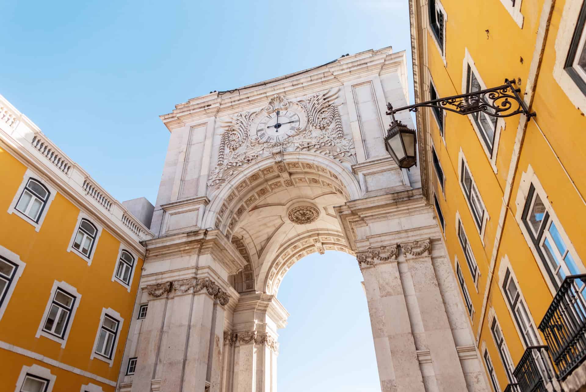 Arc de la Rua Augusta entre deux façades jaunes de la Baixa, à Lisbonne