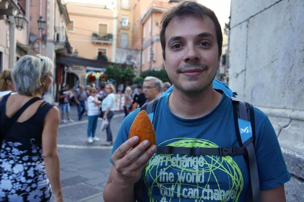 François et un arancino, dans la grand rue de Taormina